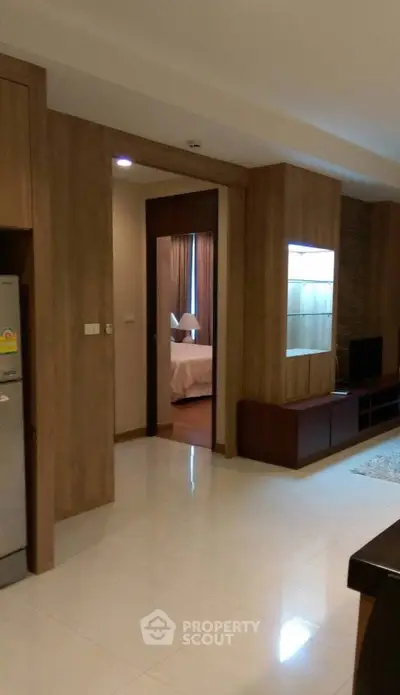 Modern apartment interior with open living area and view into a cozy bedroom.