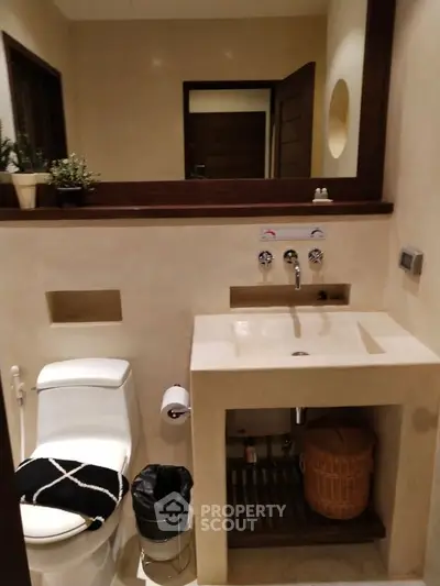 Elegant bathroom with modern fixtures and stylish decor, featuring a sleek sink and toilet.