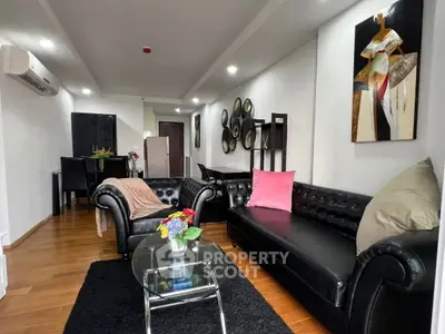 Stylish living room with black leather furniture and modern decor in a cozy apartment.