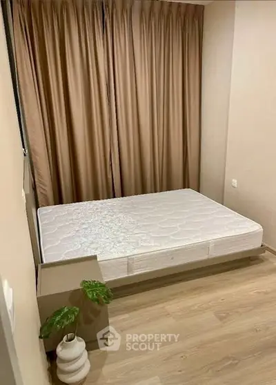 Cozy bedroom with minimalist decor and natural light, featuring a comfortable bed and elegant curtains.