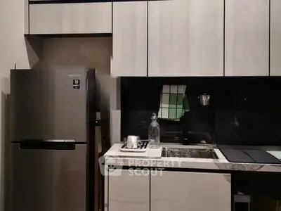Modern kitchen with sleek cabinetry and stainless steel fridge