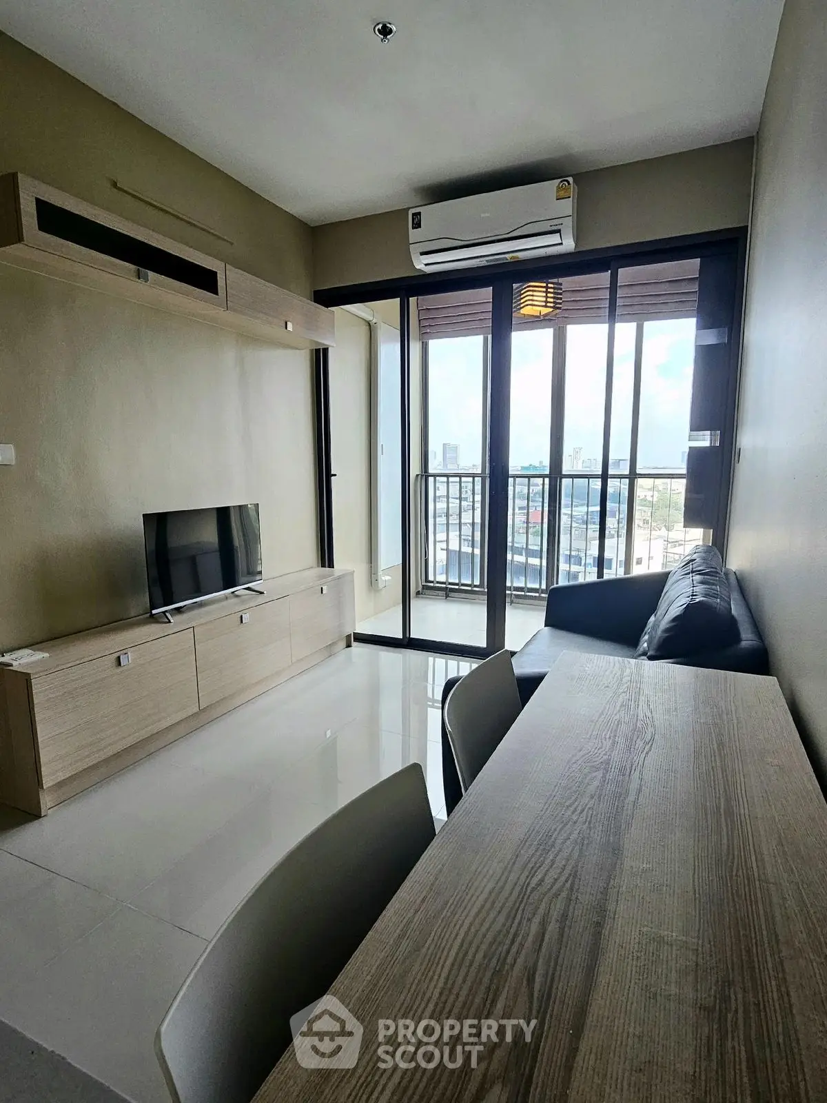 Modern living room with balcony view, sleek furniture, and natural light.