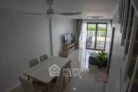 Spacious modern living room with dining area and balcony access, perfect for entertaining.