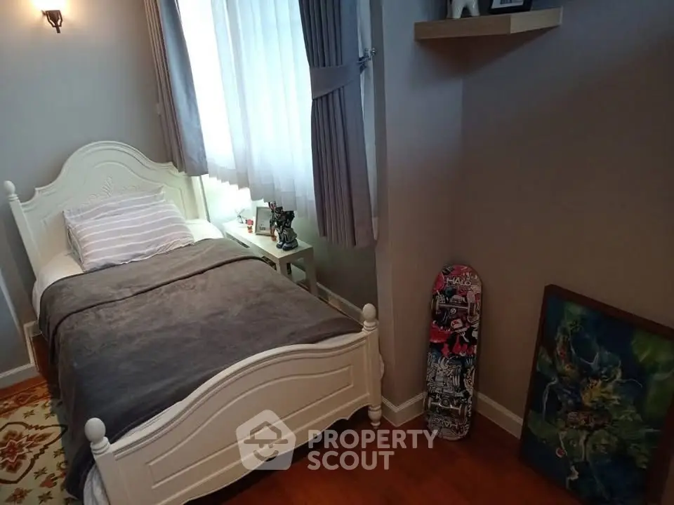 Cozy bedroom with single bed, skateboard decor, and natural light from window.