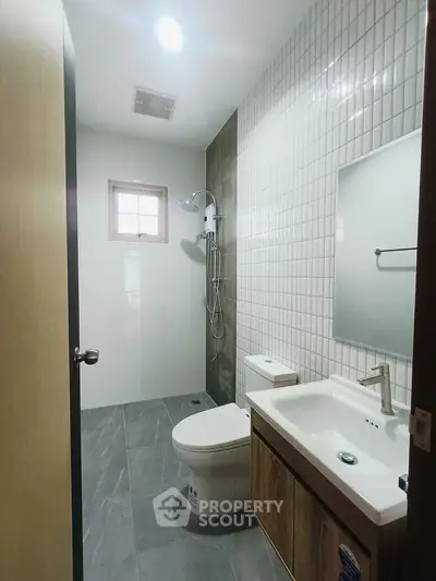 Modern bathroom with sleek fixtures and minimalist design, featuring a shower and stylish vanity.