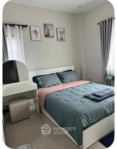 Cozy bedroom with modern decor and natural light, perfect for relaxation.