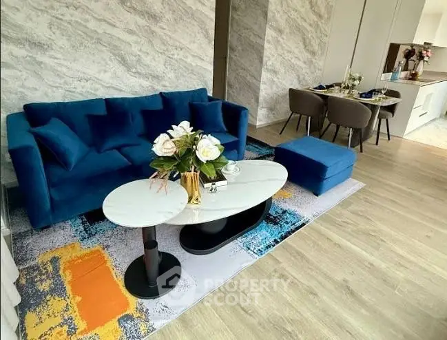 Modern living room with stylish blue sofa and elegant dining area