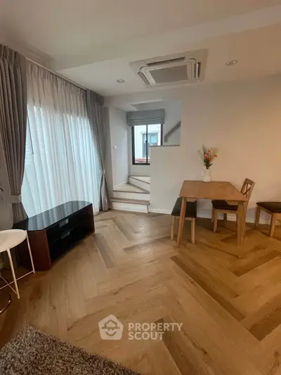 Chic modern living room with elegant wood flooring and cozy dining area