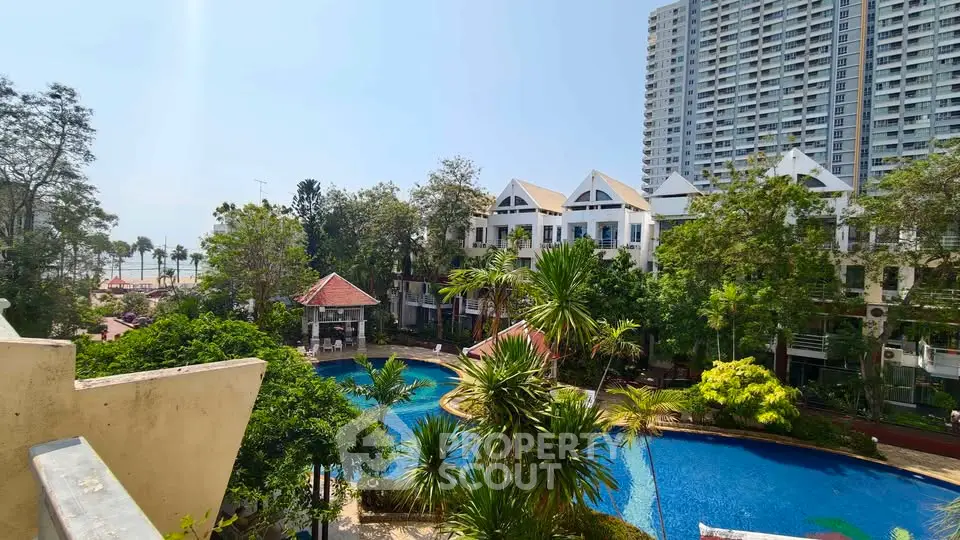Stunning view of a luxurious residential complex with a large pool and lush greenery.