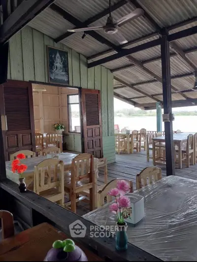 Charming rustic dining area with wooden furniture and open-air design, perfect for a cozy restaurant or cafe setting.