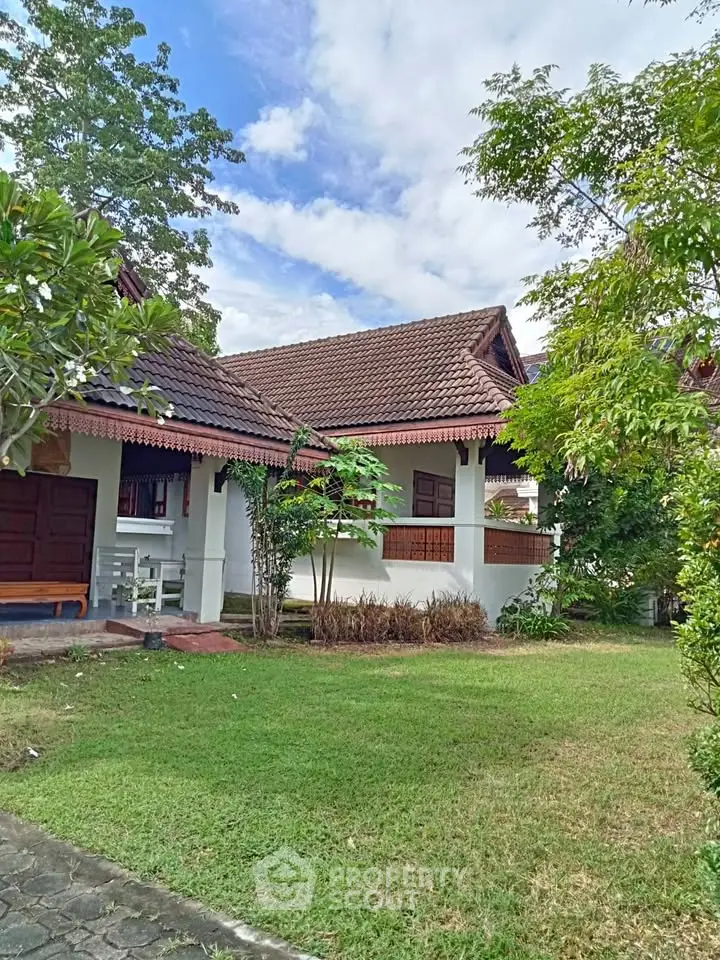 Charming traditional house with lush garden and inviting porch, perfect for serene living.