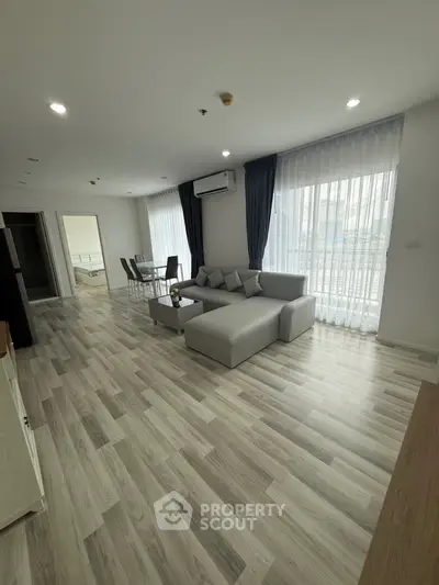 Spacious modern living room with elegant decor and large windows for natural light.