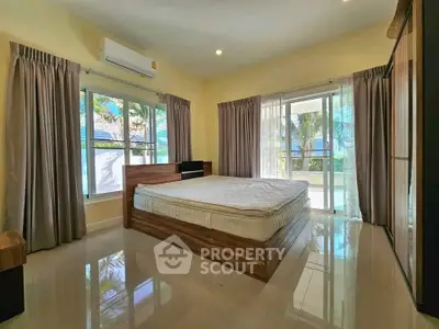 Spacious bedroom with large windows and balcony access in modern home