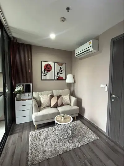 Chic modern living room with cozy sofa, stylish decor, and air conditioning in a compact apartment.