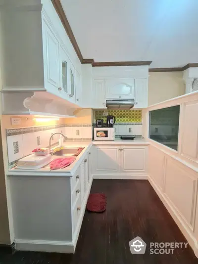 Charming kitchen space with white cabinetry and modern appliances, featuring a cozy layout and warm lighting, perfect for culinary enthusiasts.