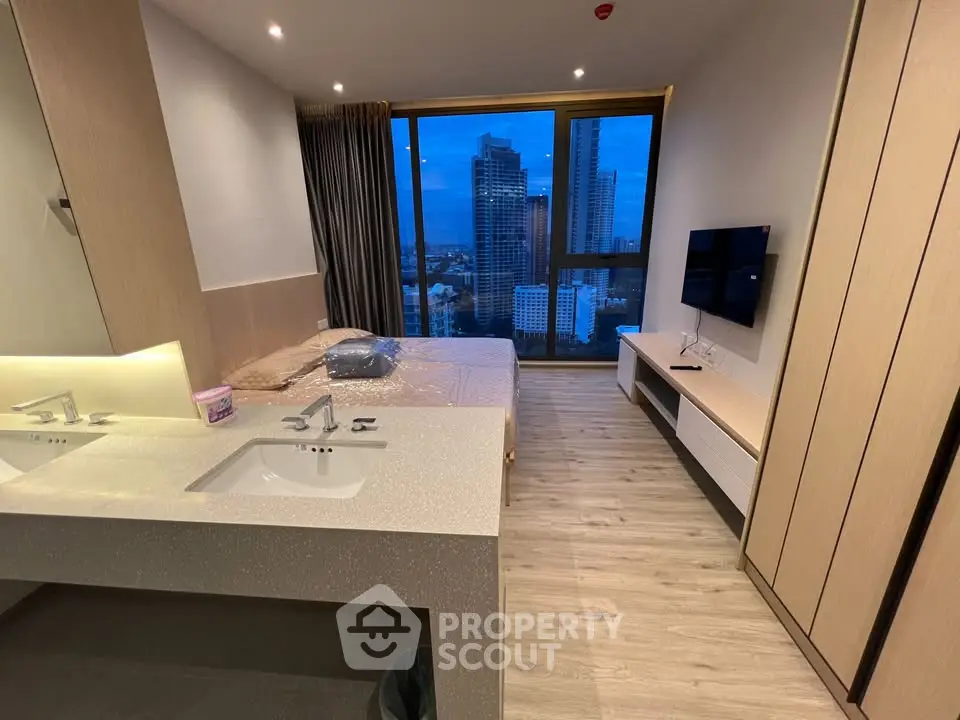 Modern bedroom with city view, featuring sleek design and large windows.