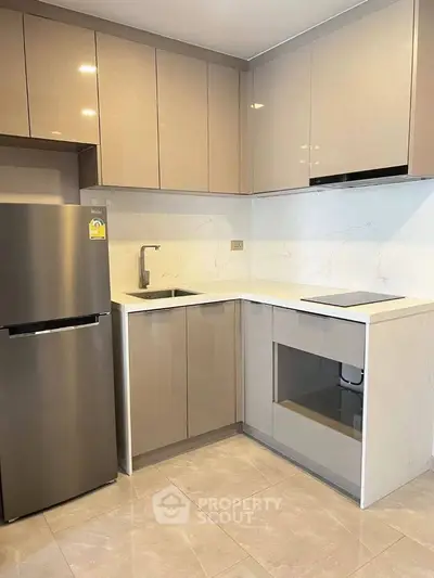 Modern kitchen with sleek cabinetry and stainless steel appliances in a stylish apartment.