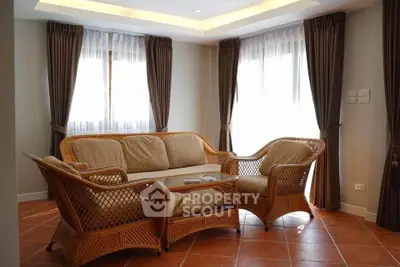 Charming living room with wicker furniture and natural light, perfect for relaxation.