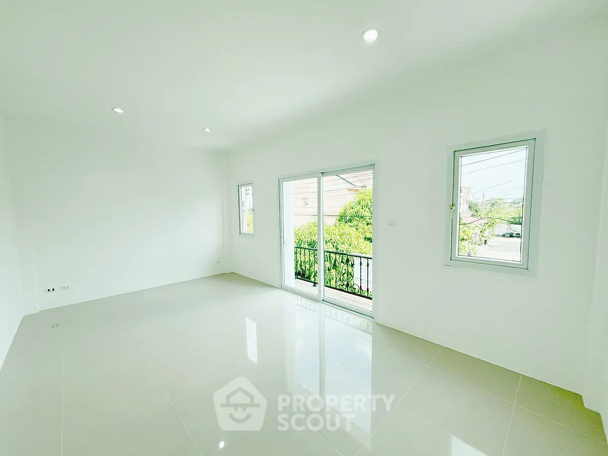 Spacious and bright empty room with large windows and glossy tiled floor, perfect for customization.