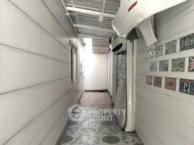 Narrow corridor with tiled floor and wall-mounted air conditioning units.