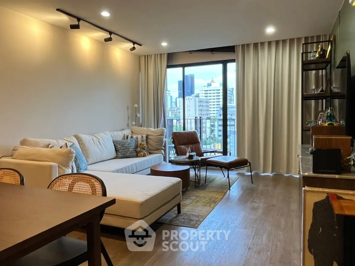Modern living room with city view, stylish furniture, and natural light.