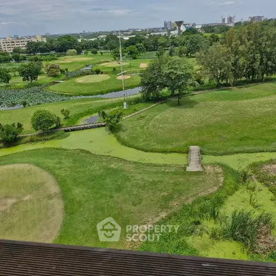 Stunning golf course view from high-rise balcony, lush greenery and city skyline.