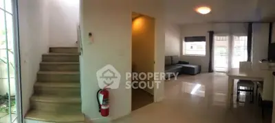 Modern interior with staircase and living area, featuring sleek design and ample natural light.