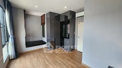 Spacious modern bedroom with hardwood floors and large windows.