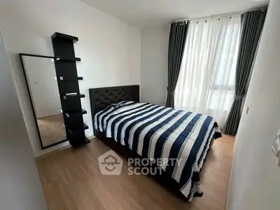 Modern bedroom with stylish decor and natural light, featuring a cozy bed and elegant curtains.