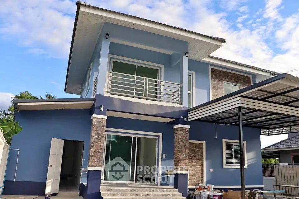 Modern two-story blue house with balcony and large windows