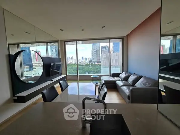 Modern living room with city view, featuring sleek furniture and large windows.