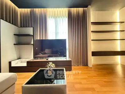 Modern living room with sleek design, featuring a large TV, elegant shelving, and ambient lighting.