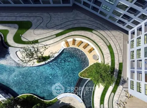 Stunning aerial view of luxury apartment complex with modern pool and landscaped garden.