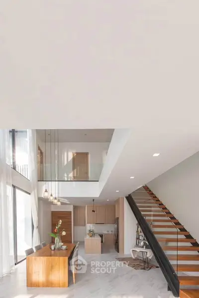 Stunning modern open-plan living area with high ceilings and elegant staircase