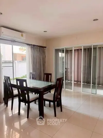 Spacious dining area with glass table and sliding doors in modern home