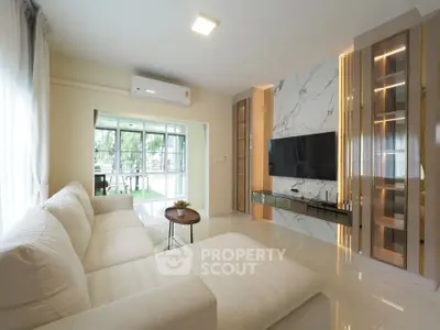 Spacious modern living room with elegant marble accent wall and large windows