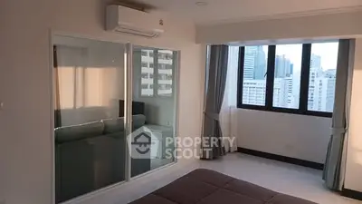 Modern bedroom with city view and air conditioning in high-rise apartment.