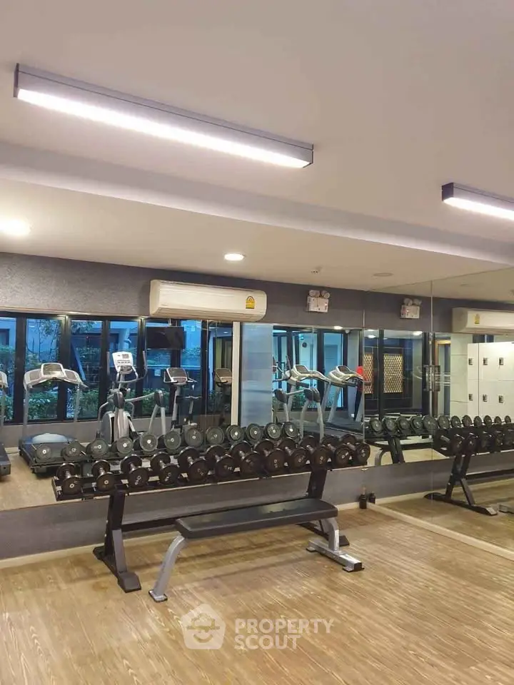 Modern gym with mirrored walls and fitness equipment in a residential building.