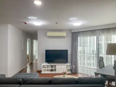 Spacious living room with modern decor and large windows for natural light.