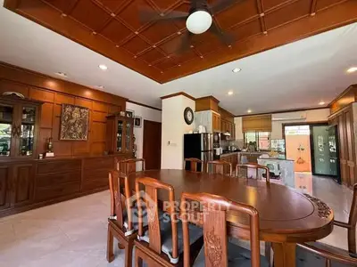 Spacious dining area with wooden furniture and open kitchen layout