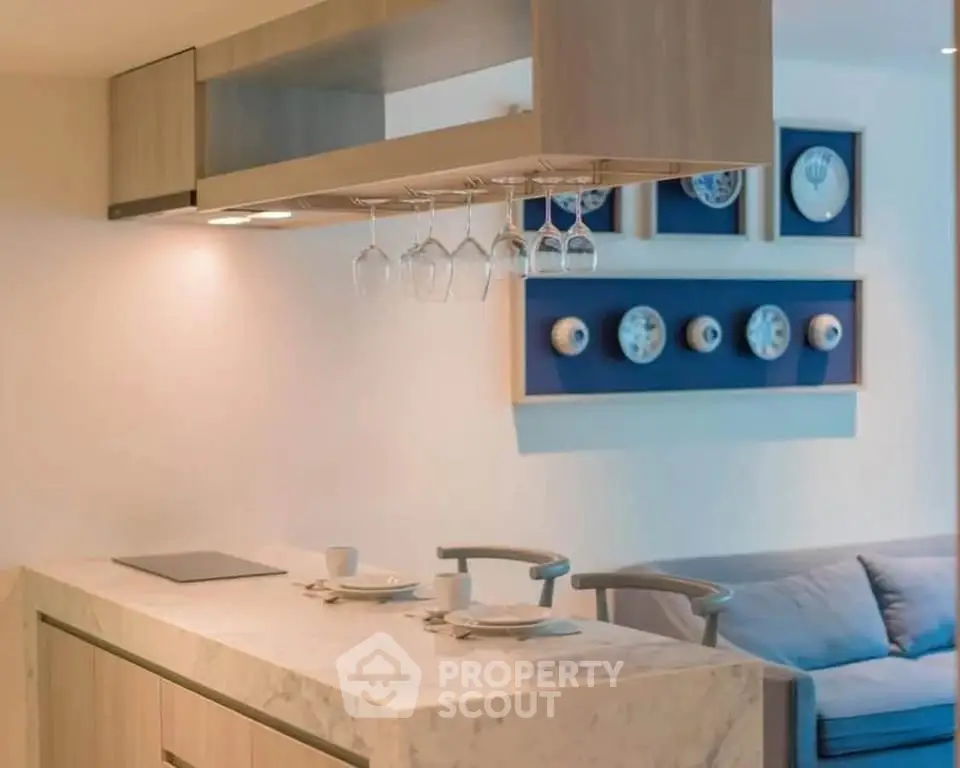 Modern kitchen with marble island and stylish decor in open layout apartment.