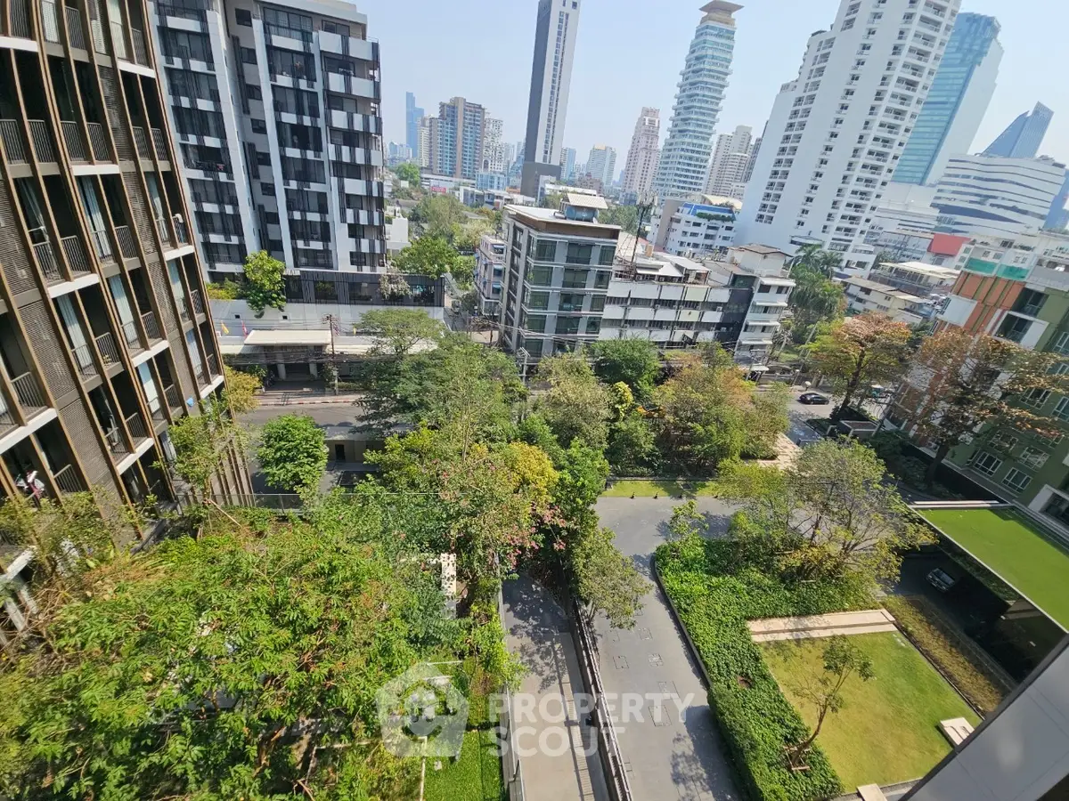 Stunning cityscape view from high-rise apartment balcony with lush greenery and modern architecture.