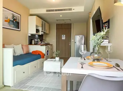 Modern studio apartment with stylish decor, featuring a cozy living area, compact kitchen, and dining space.