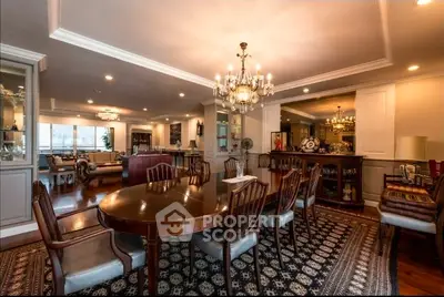 Luxurious dining room with elegant chandelier and classic wooden furniture in a spacious open layout.