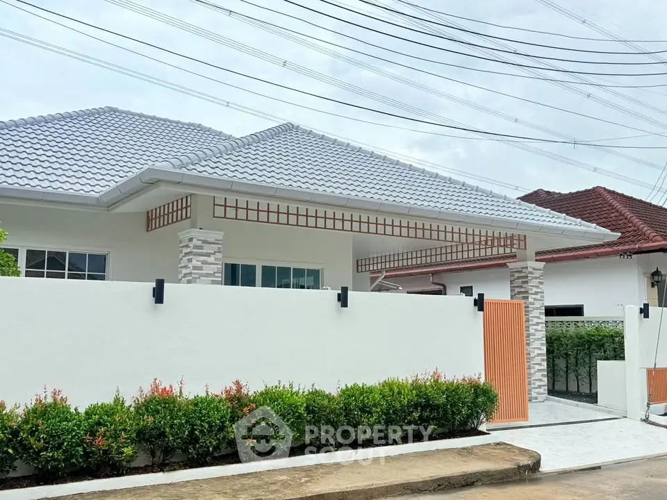 Charming single-story house with modern roof and lush garden in a serene neighborhood.