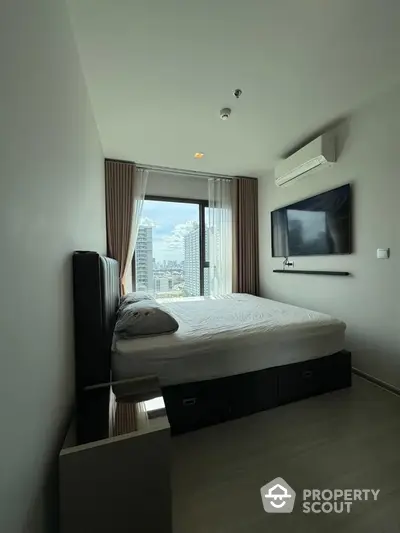 Modern bedroom with city view, featuring sleek design and wall-mounted TV.