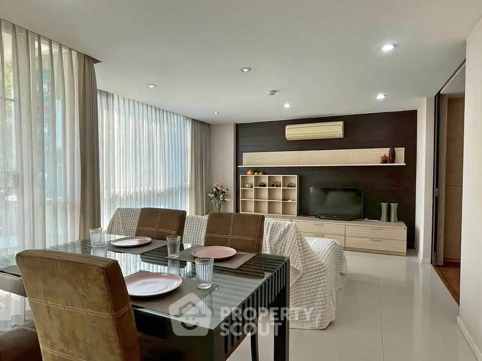 Modern living room with dining area, stylish decor, and ample natural light.