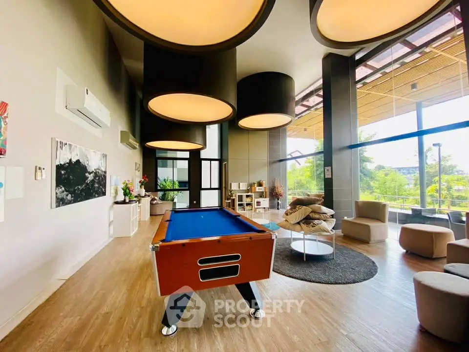 Luxurious modern living room with pool table and large windows offering scenic views.