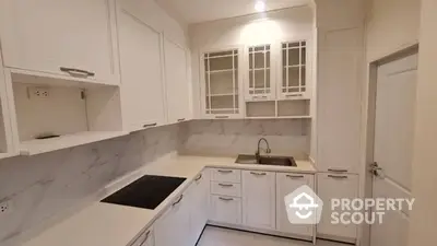 Sleek modern kitchen with white cabinetry, marble countertops, and built-in appliances, perfect for culinary enthusiasts.