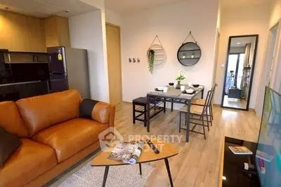 Modern living room with stylish decor and open dining area in a cozy apartment.
